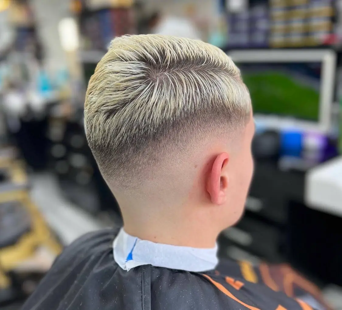 Blonde skin fade with a slicked-back top, seen from behind, cut at HAWAR BARBER in Darlington